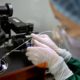 Photo of Zhou Xiaoqin installing a fine glass pipette into a sperm injection microscope