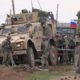 Photo of soldiers gathering next to an American military convoy
