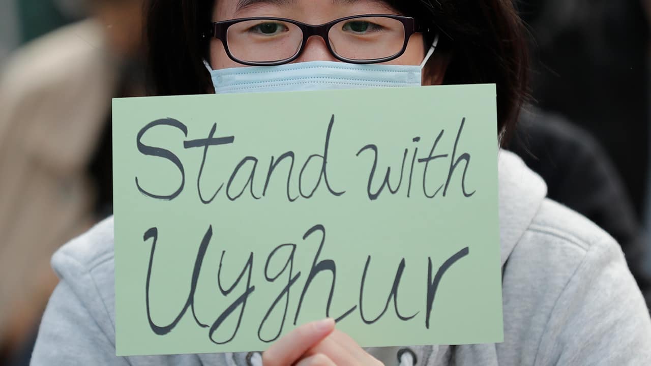 Photo of a man holding a sign during a rally to show support for Uighurs and their fight for human rights in Hong Kong