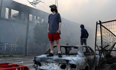 Photo of a man standing on a burnt car