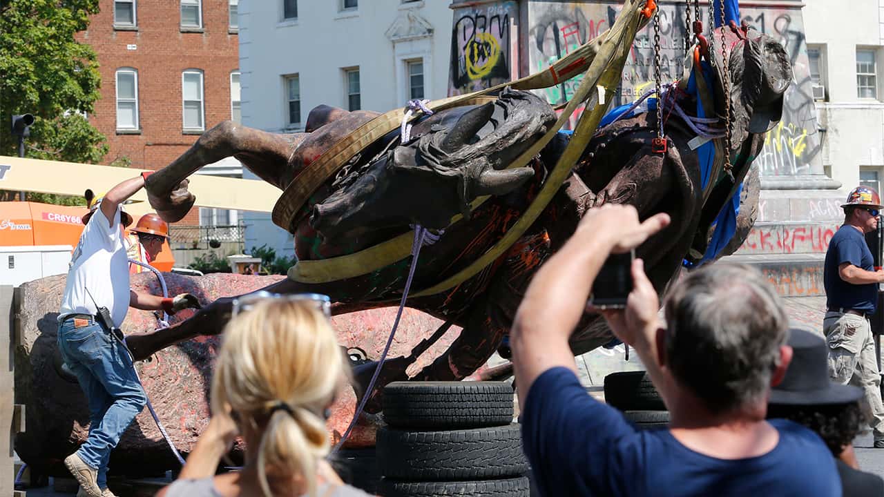 Photo of crews lowering a statue